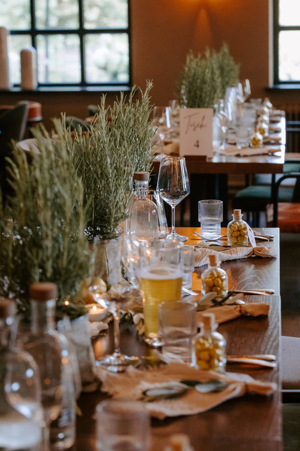 Festlich gedeckter Hochzeitstisch mit Kräutern und Kerzen