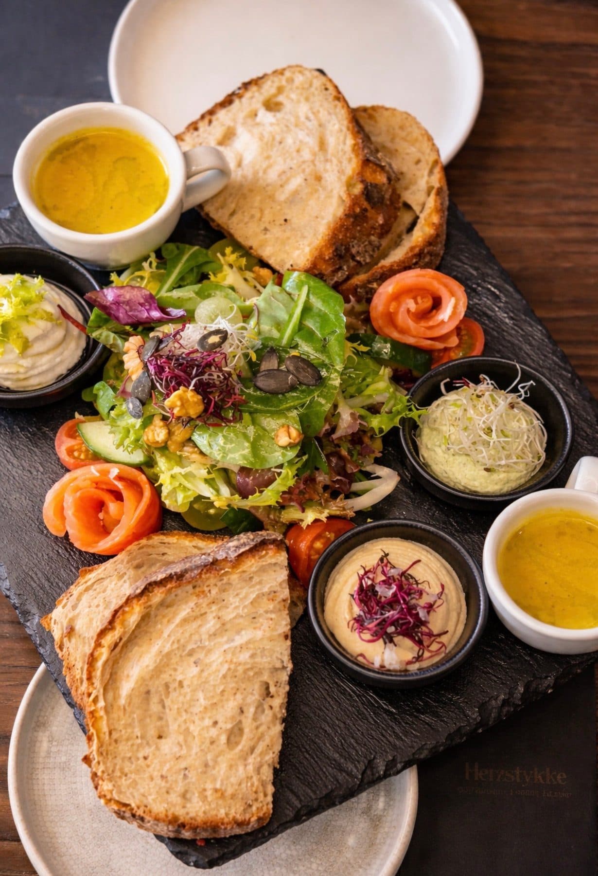 Bruschetta-Board mit Salat, Sauerteigbrot und Dips